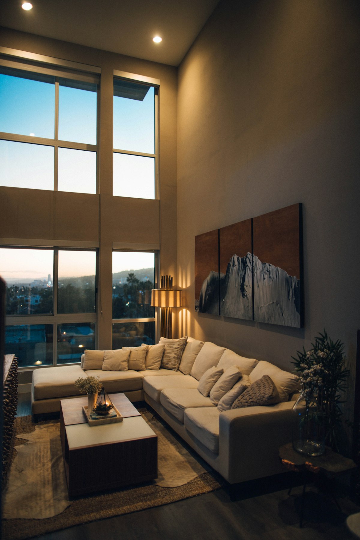 An upscale hotel suite at dusk with a city view